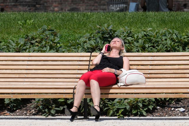 A woman sunbathes in a park in Milan, Italy