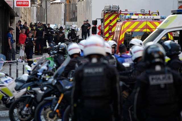 Police wait behind emergency vehicles in the street