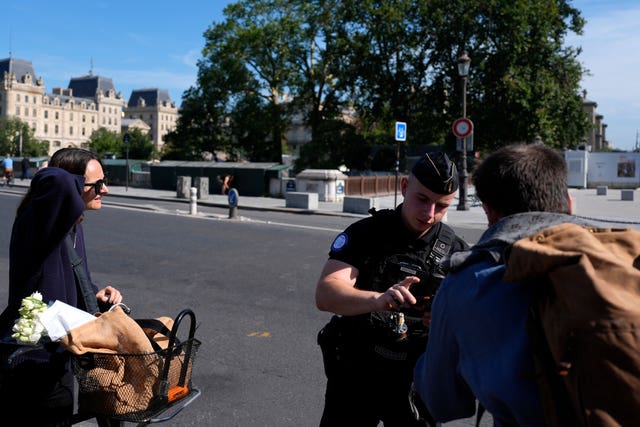 A police officer talks to two people on the street