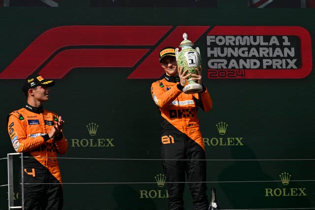 Oscar Piastri (right) celebrates on the podium with Lando Norris