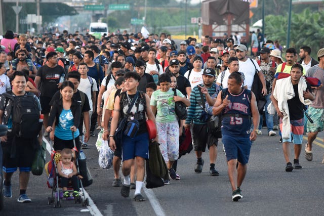 Migrants walk along the highway through Suchiate, Chiapas state