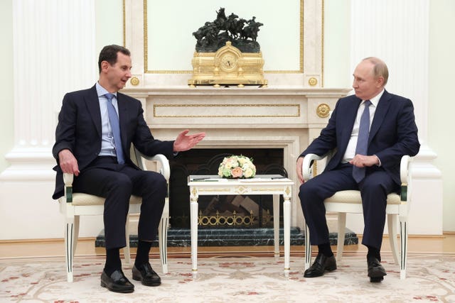 Bashar Assad, left, speaks with Vladimir Putin