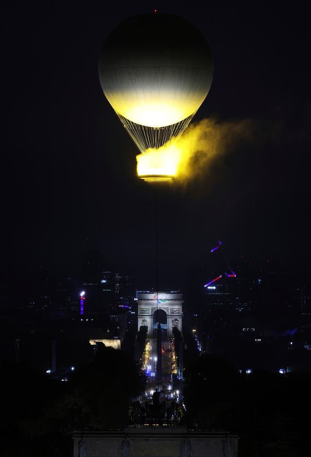A balloon carrying the Olympic Cauldron rises over the Arc de Triomphe 