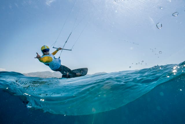 A kitesurfer looks back at the photographer while on the water. 