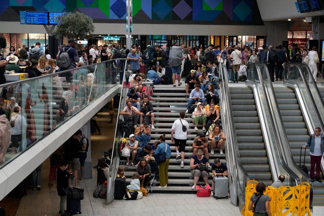 Passengers sit on stairs at the Gare de Montparnasse