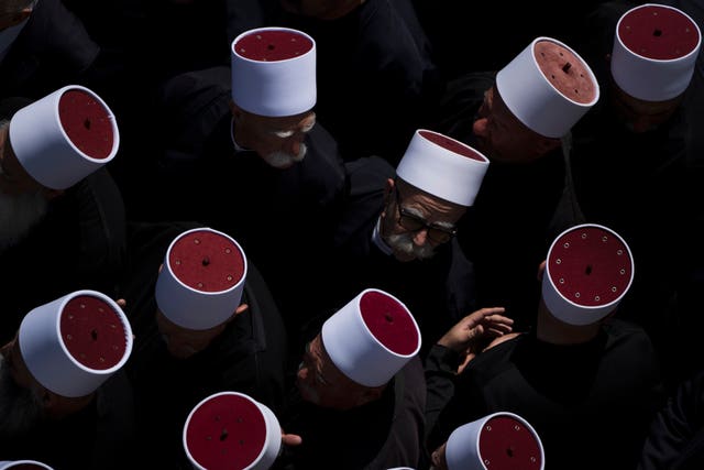 Druze clergymen attend the funeral of some of the 12 children and teenagers killed in a rocket strike 