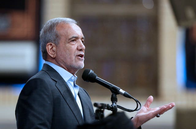 Iranian president Masoud Pezeshkian speaks at a microphone