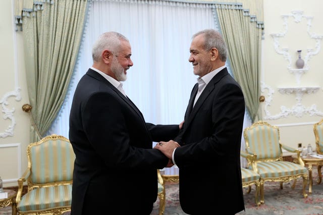 The Iranian President and Mr Haniyeh shake hands