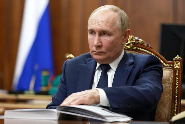 Russian President Vladimir Putin listens to Rostec State Corporation CEO Sergei Chemezov during their meeting at the Kremlin in Moscow