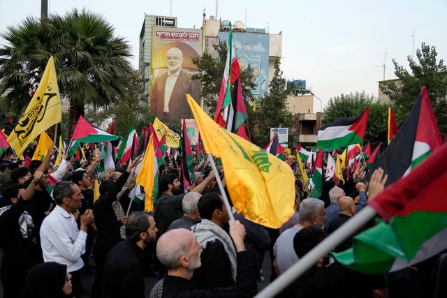 Iranian protesters wave Iranian, Palestinian and Lebanon’s militant Hezbollah group flags in a demonstration