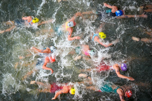 Triathletes swim in the Seine, with the photograph taken from above