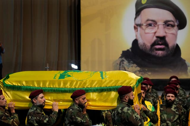 Hezbollah fighters carry the coffin of Fouad Shukur