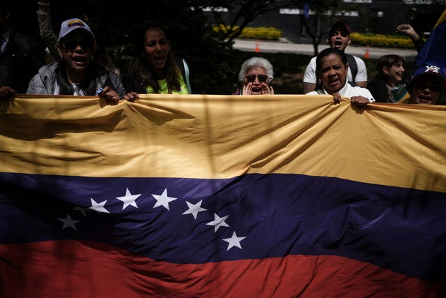 Demonstrators holding a Venezuelan flag outside that nation’s consulate in Bogata, Colombia