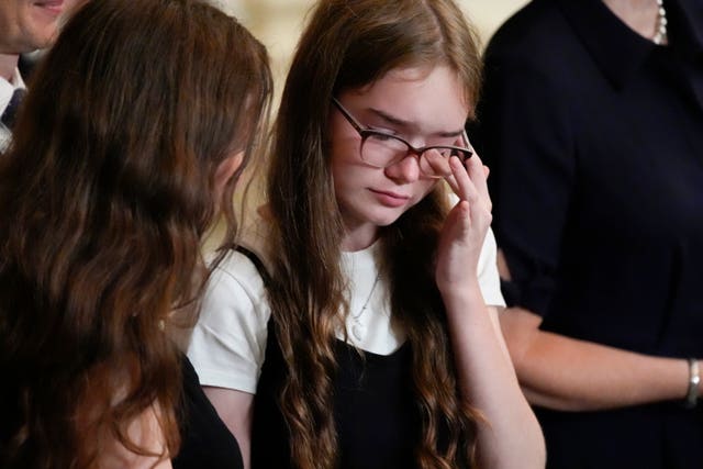 Alsu Kurmasheva's daughter wiping away a tear during Mr Biden's White House address