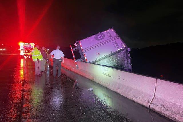 A lorry dangles over the edge of a bridge