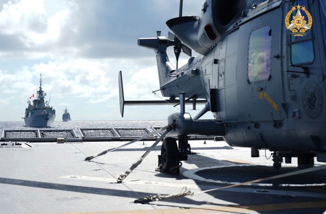 A helicopter on the deck of an aircraft carrier