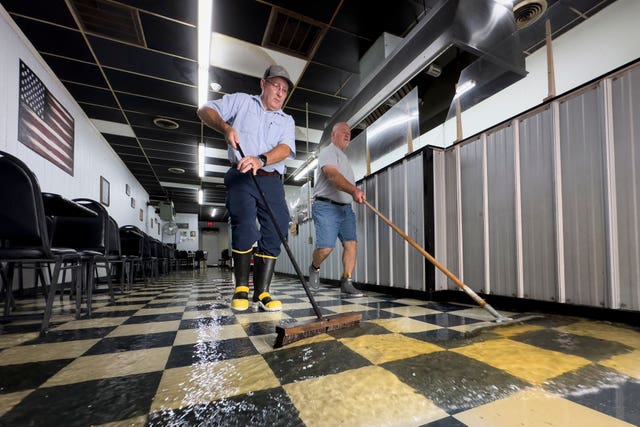 Randy Sikes sweeps water out of Diamond Dave’s Grill