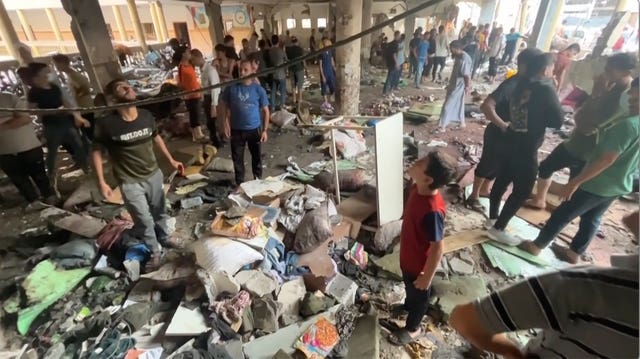 People inspect the rubble of the school