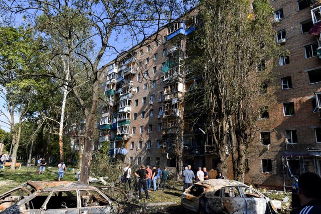 People gather at an apartment building damaged after Ukrainian shelling in Kursk, Russia (AP)