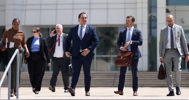 George Santos, centre, leaves court following a hearing in his fraud trial 