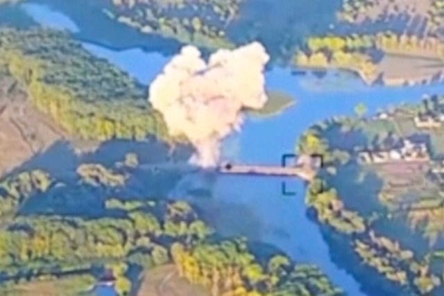 Aerial view of smoke billowing from a bridge in the distance