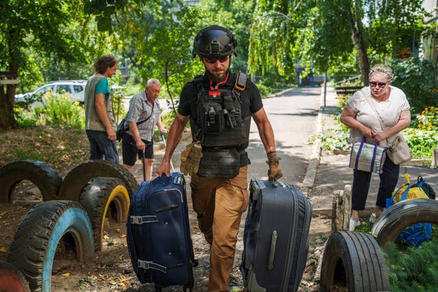 A volunteer on East SOS helps to carry bags of evacuees in Selidove, Donetsk region, Ukraine 