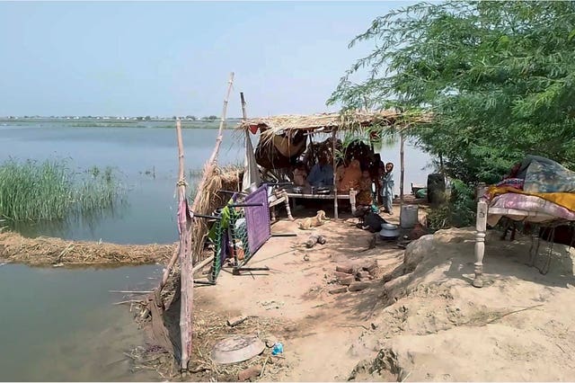 A family take refuge after their house flooded near Sohbat Pur, an area of Pakistan’s southwestern Baluchistan province