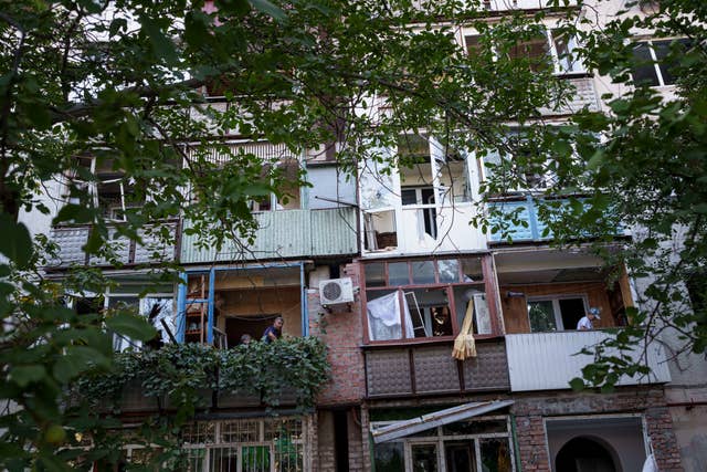 People clearing broken glass from their balconies in Pokrovsk, Ukraine 