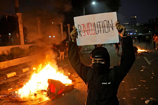 A protester holds a poster during a rally against controversial changes to election laws in Indonesia 