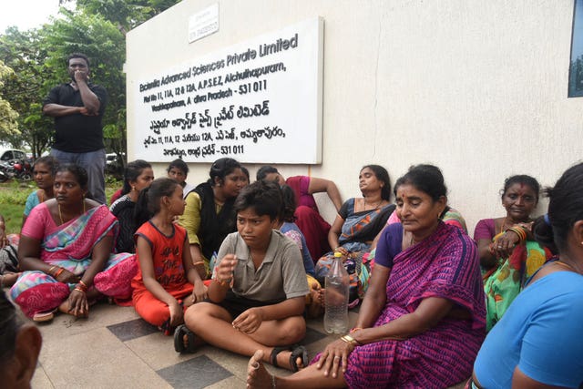 Relatives of the victims killed in the fire sitting outside the factory