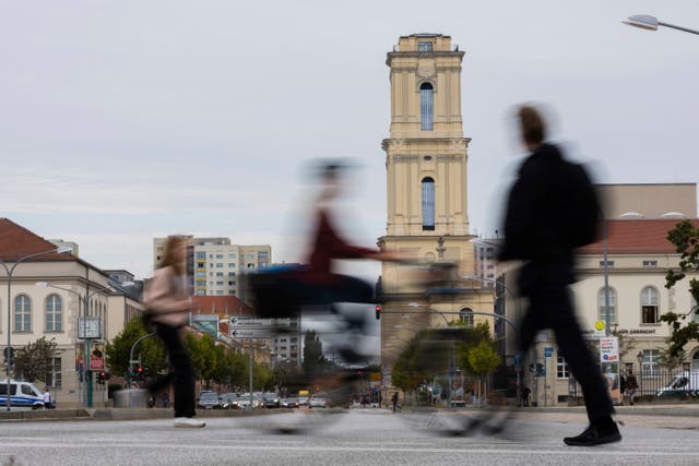 Passers-by walk in front of the tower of the Garrison Church in the city centre in Potsdam, Germany 