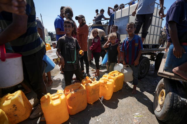 Displaced Palestinians line up to collect water in Deir al Balah, central Gaza Strip