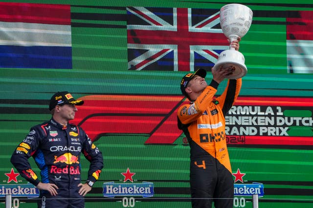 Lando Norris holding up his trophy