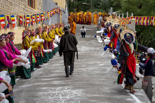 People in costumes prepare to welcome the Dalai Lama