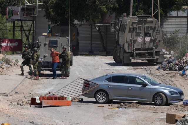 A Palestinian man is detained by members of the Israeli forces