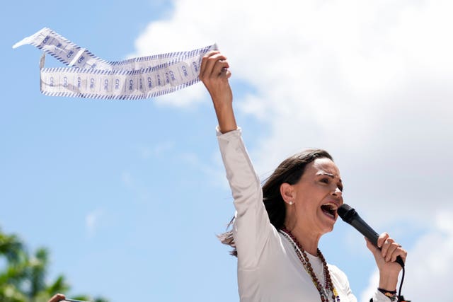 Opposition leader Maria Corina Machado displays vote tally sheets during the protest 