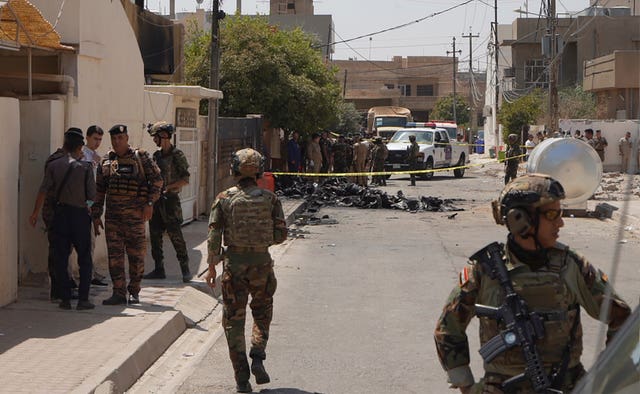 Iraqi Army soldiers stand guard near the debris of a drone shot down by Iraq’s air defences in Kirkuk, Iraq