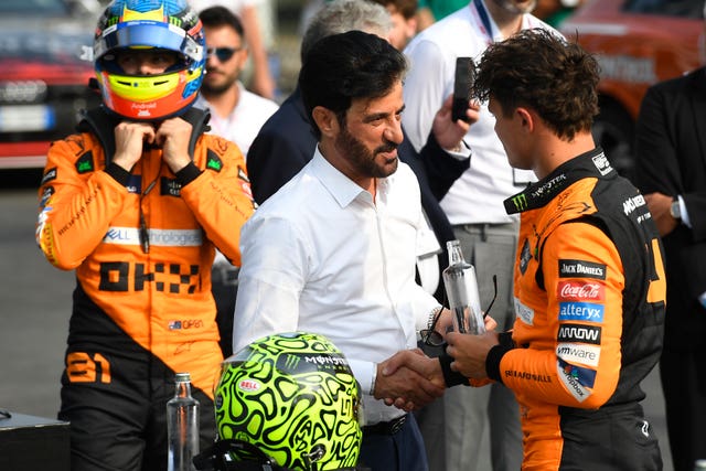 Lando Norris is congratulated by FIA President Mohammed Ben Sulayem