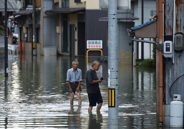 Two people walking through flood water