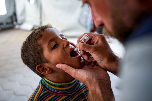 A health worker administers a polio vaccine to a child at a hospital in Deir al-Balah, central Gaza Strip