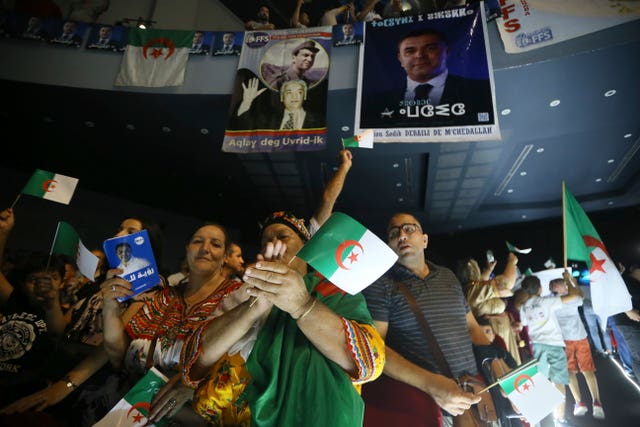 People hold placards at an election rally in Algeria