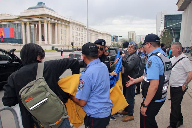 Security men take a Ukrainian flag from protesters 