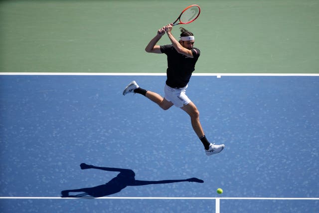 Taylor Fritz, of the United States, returns a shot to Alexander Zverev