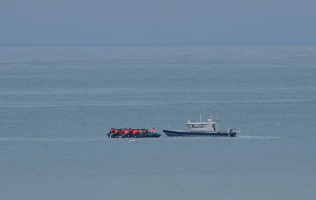 A boat thought to be with migrants is escorted by a vessel from the French Gendarmerie Nationale