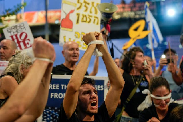 A demonstrator with his hands tied calls for a cease-fire deal and the immediate release of hostages held in Gaza during a protest in Tel Aviv, Israel 