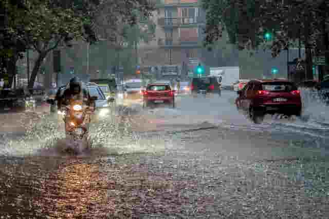 Cars drive through flooded streets