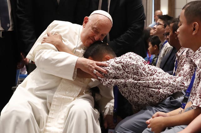 Pope Francis blesses a beneficiary from charitable organisations at the Indonesian Bishops’ Conference Headquarters in Jakarta 