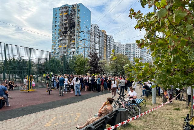 People gather to talk to local officials at the site of the damaged residential building, following an alleged Ukrainian drone attack in Ramenskoye, outside Moscow, Moscow region