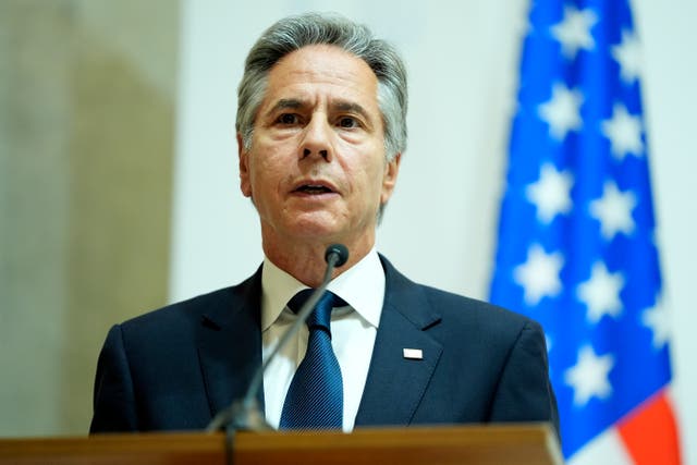 US secretary of state Antony Blinken with an American flag behind him