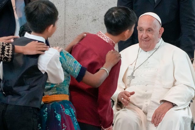 Pope Francis is welcomed by dancing children as he arrives at Singapore